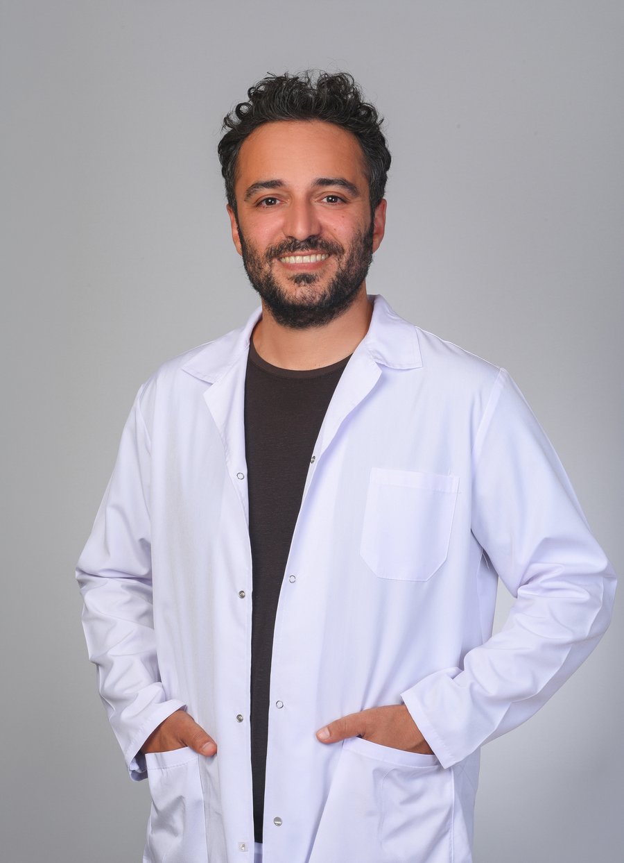 Prof. Dr. Abdullah Orhan Demirtaş, Adana ve Mersin'de hizmet veren Kardiyoloji ve Kardiyak Elektrofizyoloji Uzmanı, beyaz doktor önlüğüyle stüdyo portresi